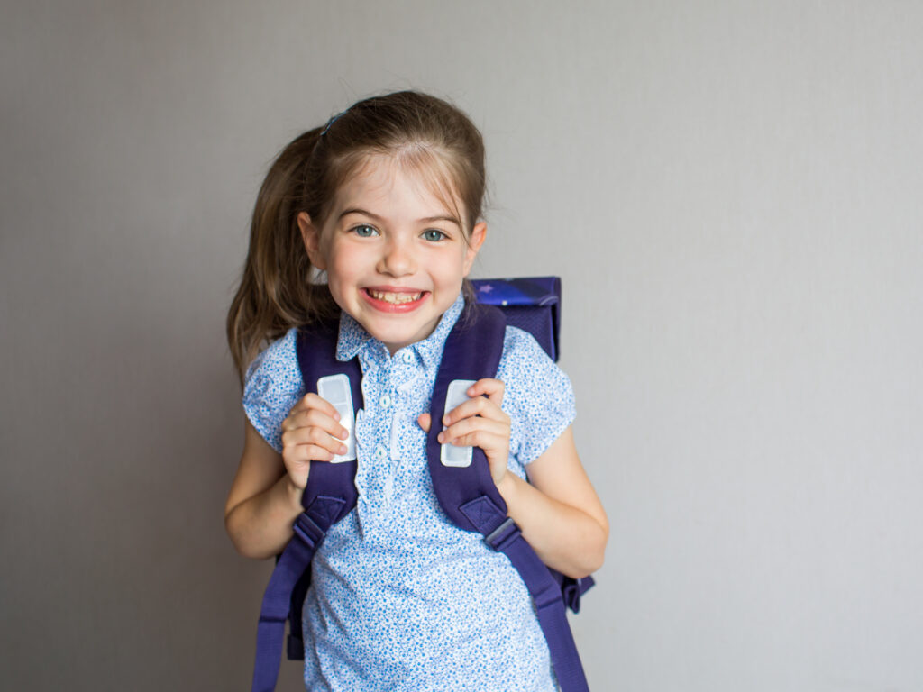 Portrait,Of,A,Smiling,Schoolgirl,In,Uniform,With,School,Backpack